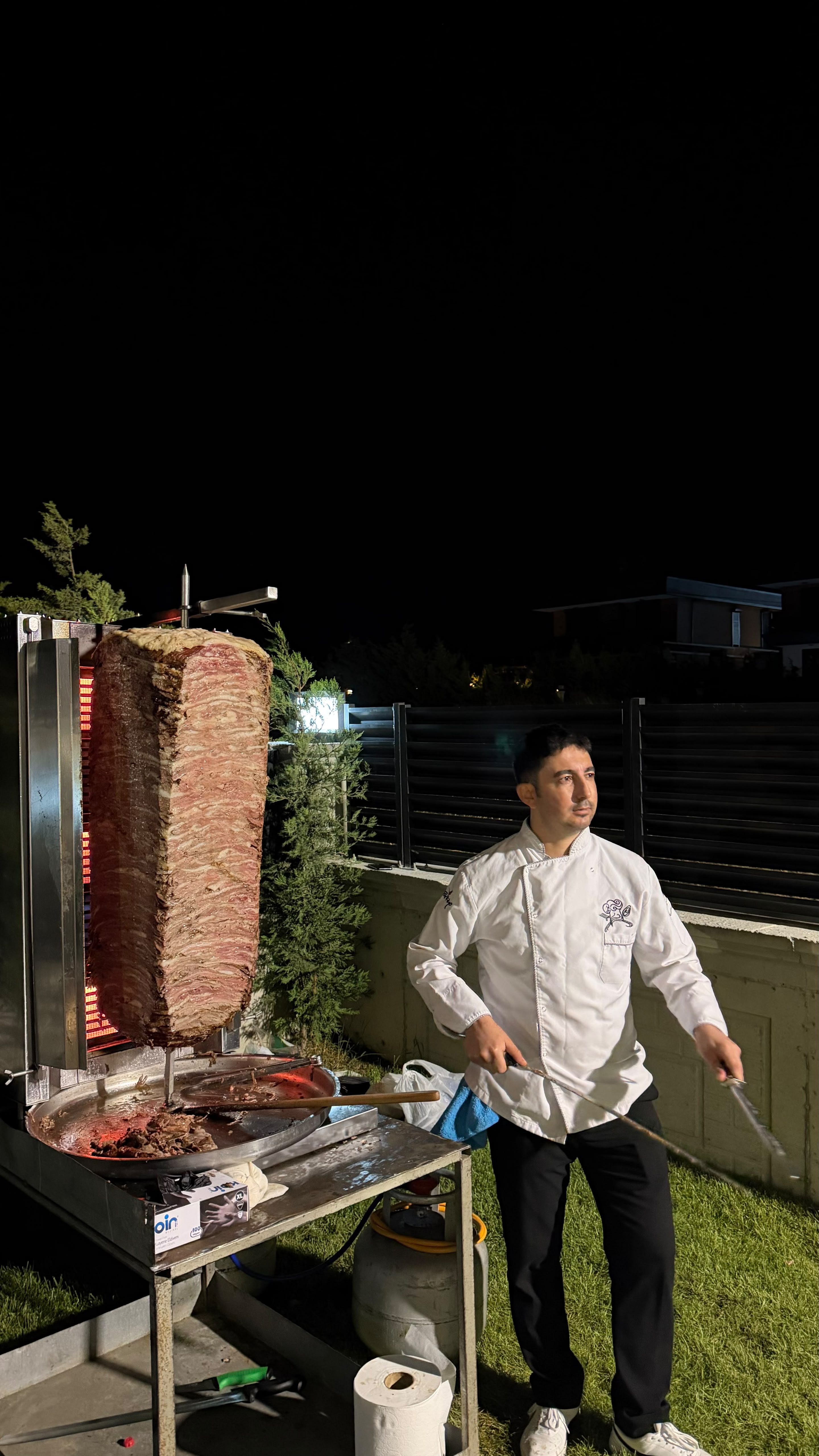 Gece catering organizasyonunda döner ustası şişin başında