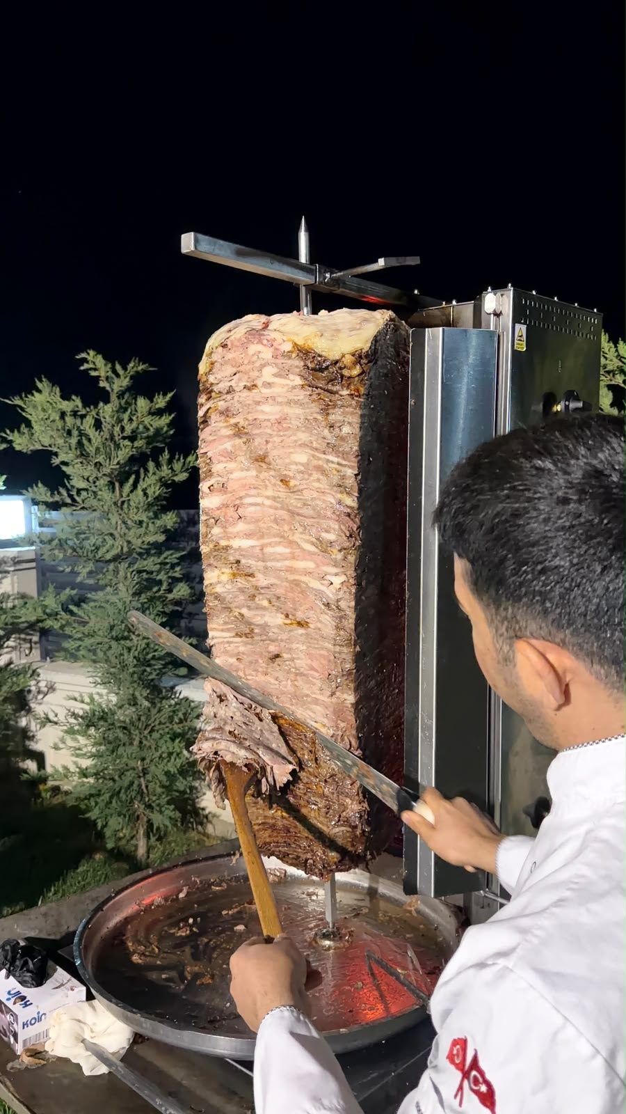 Döner ustası misafirler için şişten et döner kesiyor